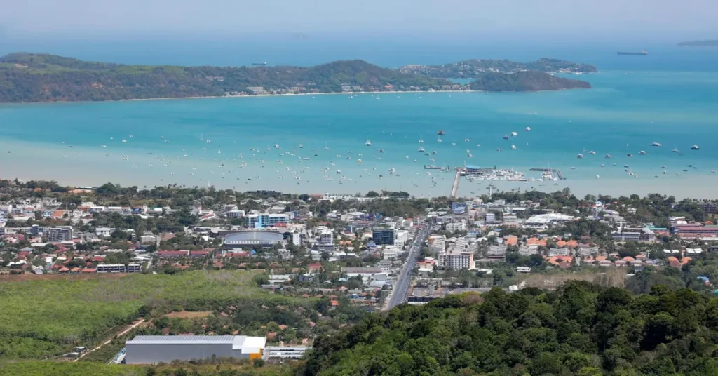 Serene Karon Beach in Phuket with golden sands and a calm, crystal-clear sea.