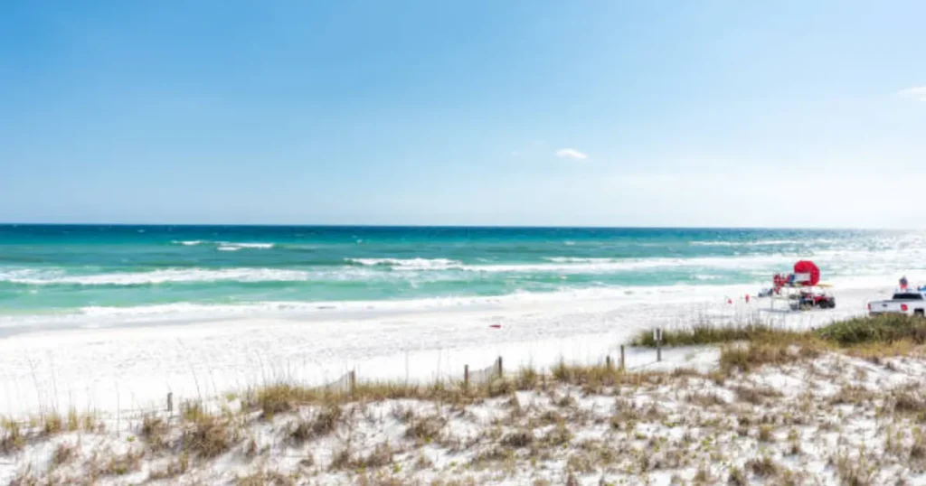 A serene image of Miramar Beach with clear blue waters and soft white sands, ideal for relaxation and adventure.