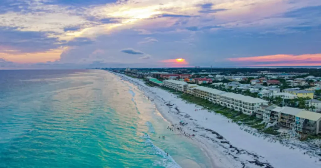 A breathtaking sunset over Miramar Beach with the golden sky reflecting over the beach and shoreline.